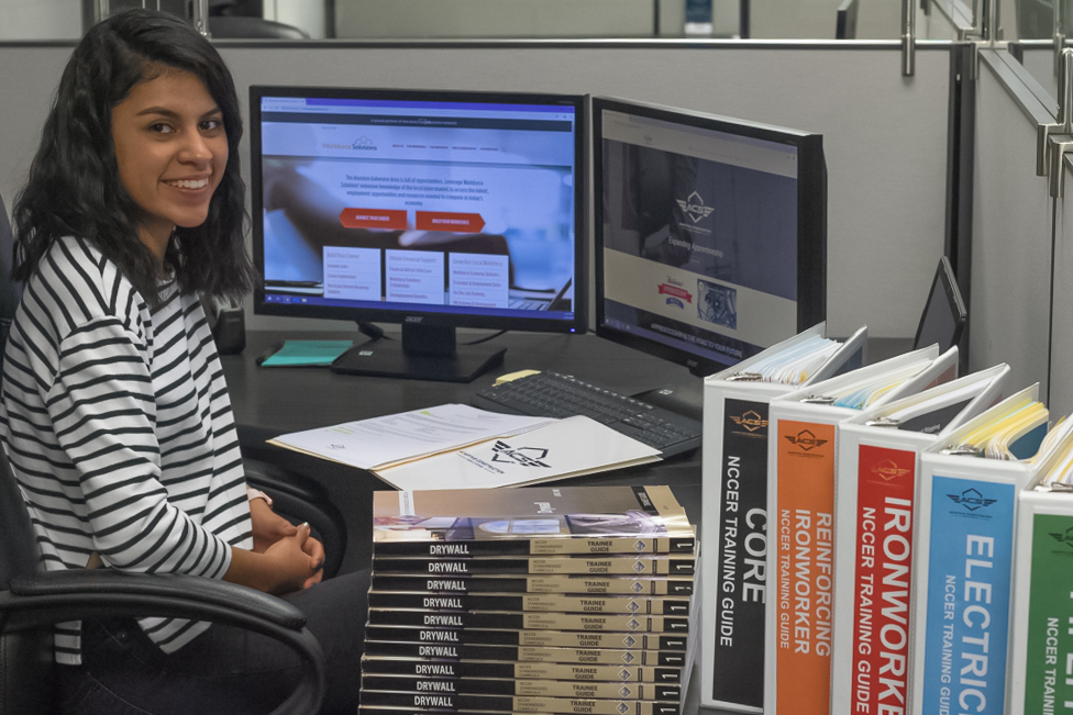 Intern Rebecca working at computer with a smile on her face