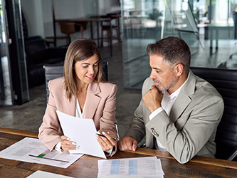 Co-workers talking at a desk