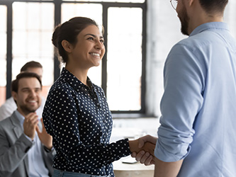 Female and male employees shaking hands