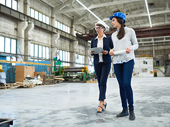 Photo of two women walking in a warehouse