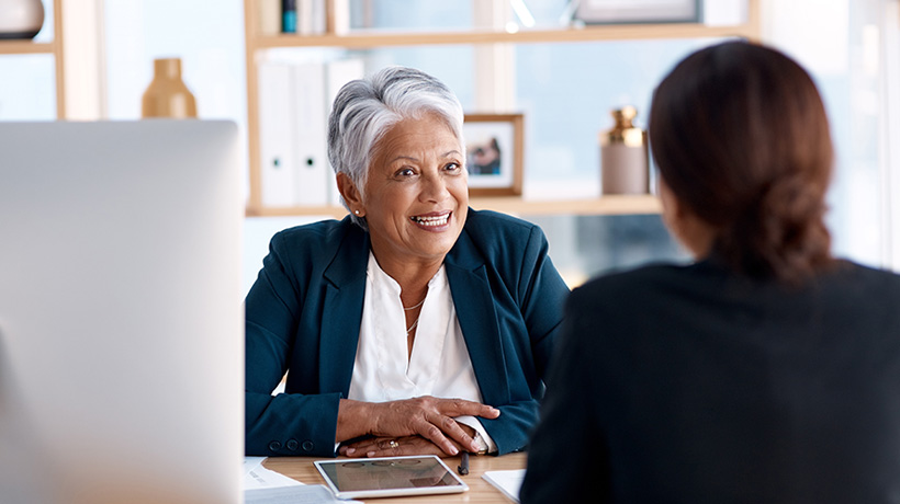 Two women talking at a desk